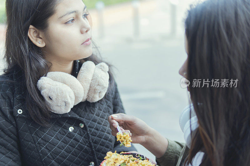 女孩们吃着街边小吃享受着。