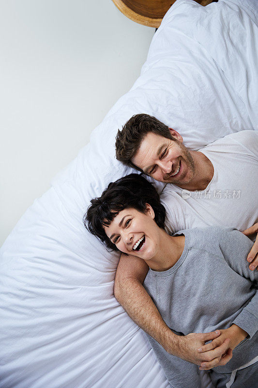 清晨，一对笑嘻嘻的年轻夫妇躺在床上
