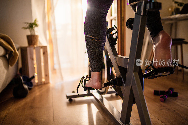 女性足部训练期间在家锻炼自行车