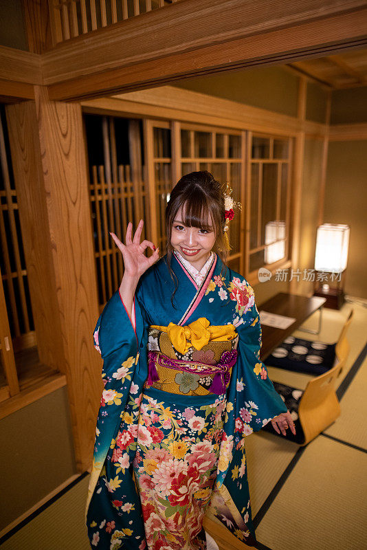 年轻女子在“Furisode”和服享受在日本“ryokan”酒店