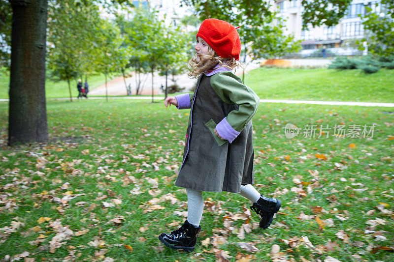 快乐的小女孩在公园里跑步。