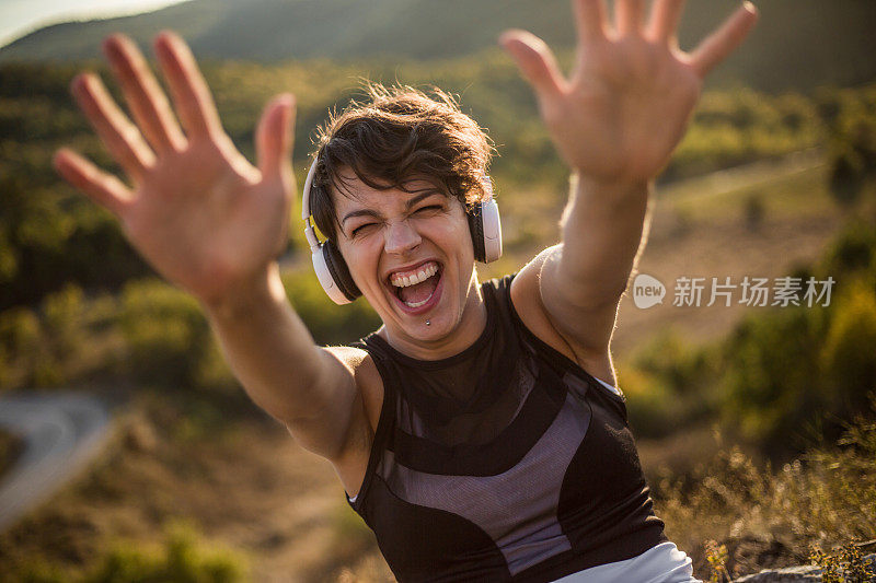 在大自然中锻炼后休息的健康女性。一个快乐，美丽的女人享受乐趣和笑声训练后的自然。