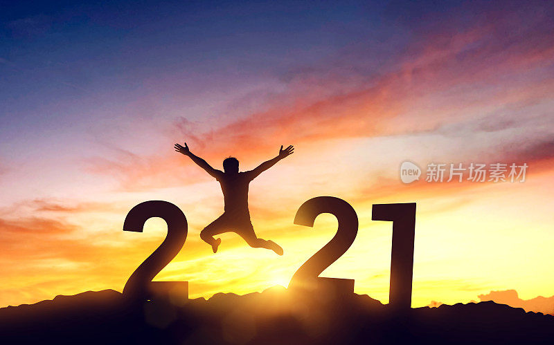 剪影年轻人在山上跳和2021年，同时庆祝新年，胜利和成功的概念。