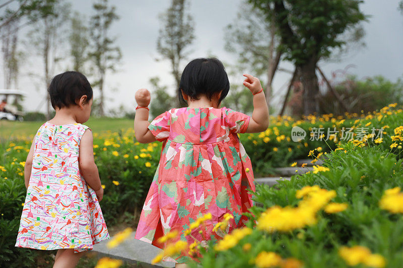 两个中国女孩在公园里美丽的小路上玩耍