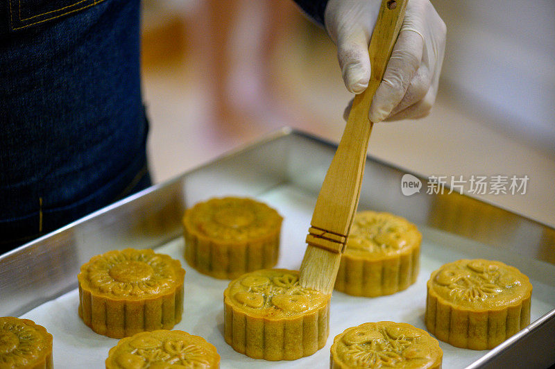 面包师在烤盘上用鸡蛋面团画自制月饼