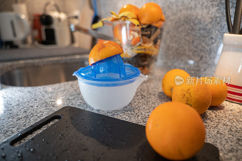 厨房里有柑橘榨汁机，柜台上有橙子