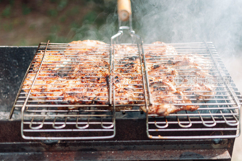 用酱汁和香料腌制的烤鸡腿。多汁的肉块浸在从木炭中冒出的烟中。在篝火上烤着炸鸡串。篝火做饭的季节。