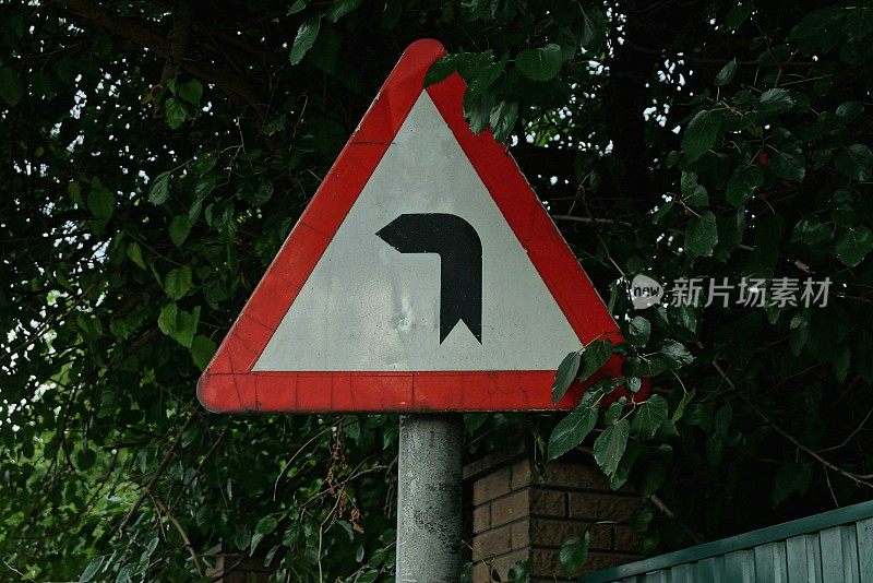 一个三角形的路标表明道路有危险转弯