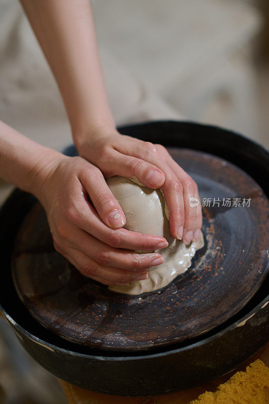 人类的手在陶轮上塑造粘土的特写