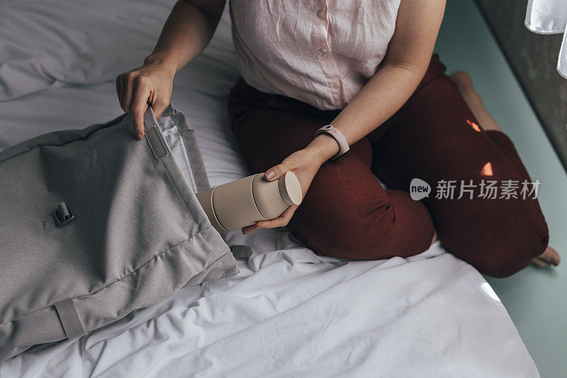 一个白人女人在卧室里装着一瓶水