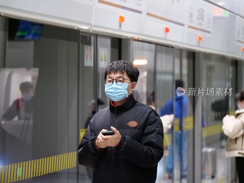中国上海——2022年1月7日:人们戴着口罩站在地铁站里