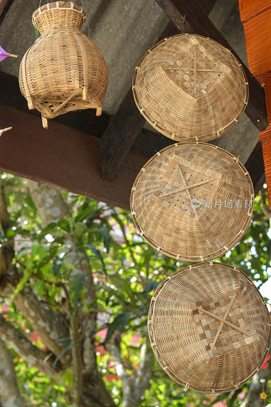 柳条篮，手工制作的木纹或竹纹柳条，挂在木梁上。