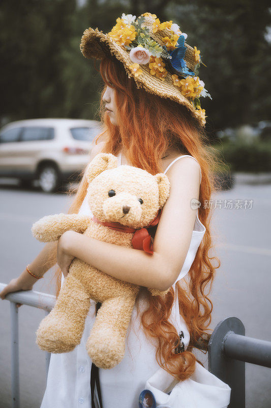 在成都的下午，一个年轻的亚洲女孩戴着花圈站在路边，抱着一只熊，望着远方