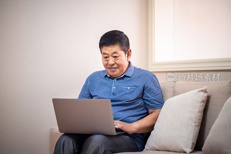 一名中国老人在使用笔记本电脑