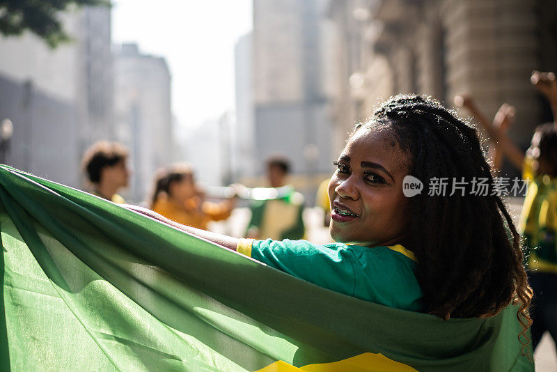 户外举着巴西国旗的中间女子的肖像