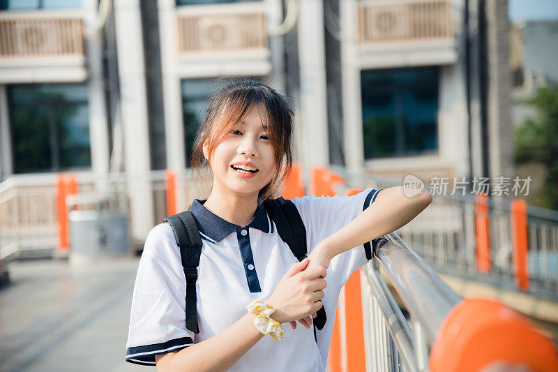 亚洲女孩在一个阳光明媚的日子放学回家