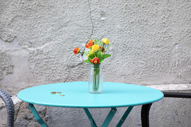 花瓶里的花和蓝色咖啡桌上的硬币