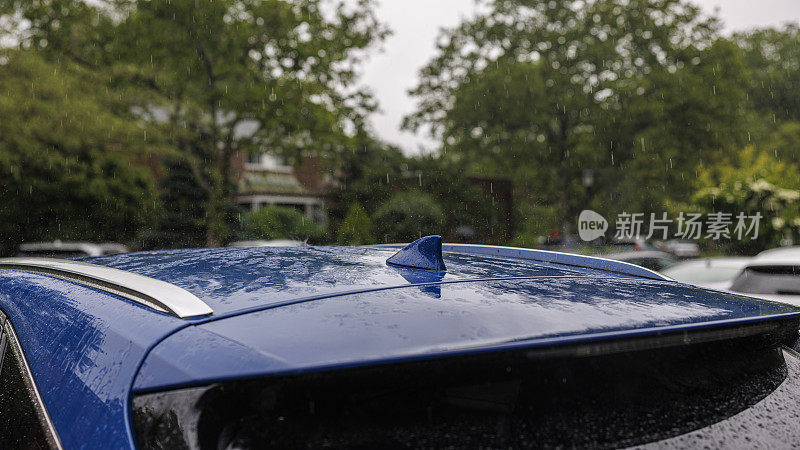 淋湿的车在雨中停在一个居民区。