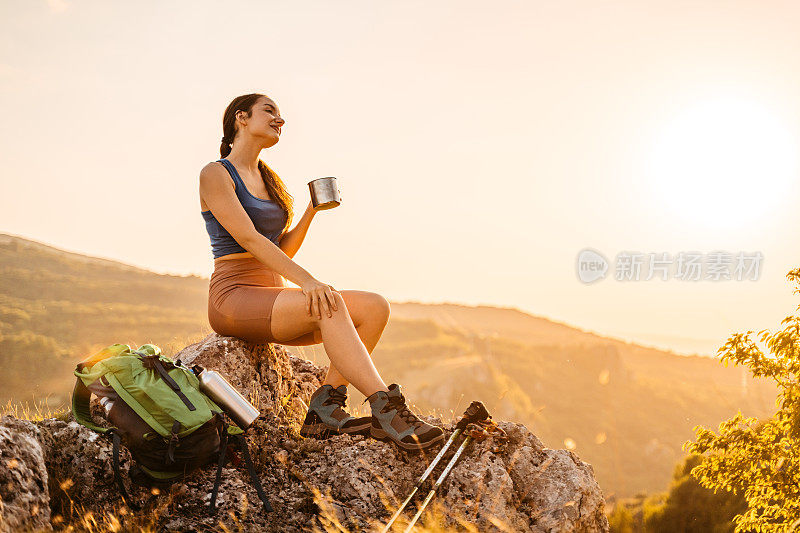 徒步旅行后在山上喝咖啡的年轻女子