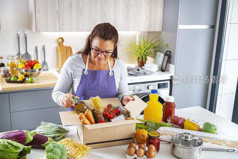 厨房里的妇女正在往捐款箱里装各种食物