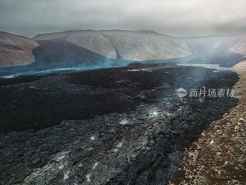 法格拉达斯夫亚尔火山的熔岩流入山谷，喷出蒸汽和气体