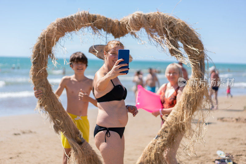 深情幸福的一家人在沙滩上自拍，享受夏日假期