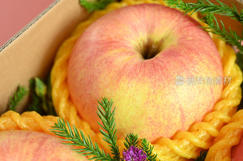 粉色背景的盒子里有漂亮的苹果，健康的水果