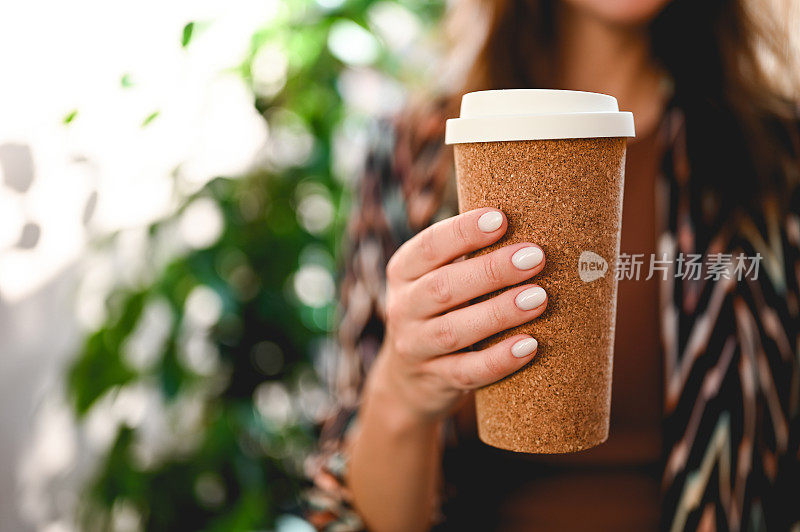 生态生物把咖啡杯拿在女人手里。特写，选择性聚焦。