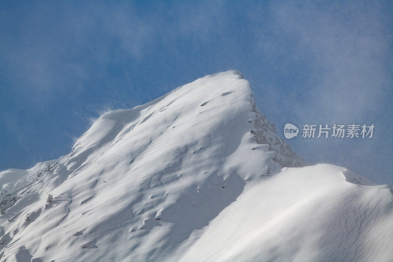 美国蒙大拿州库克市附近的山顶被雪覆盖，被风吹过