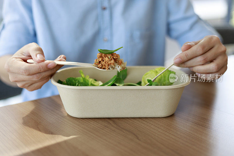 一名妇女正在享受一顿健康的素食午餐。美味均衡的食物概念。生态零废餐具。食品外卖