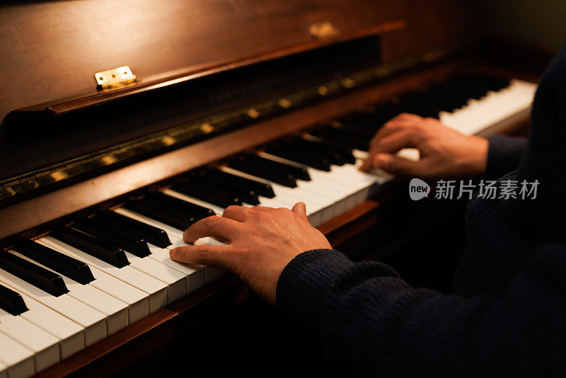男性手弹钢琴的特写镜头。
