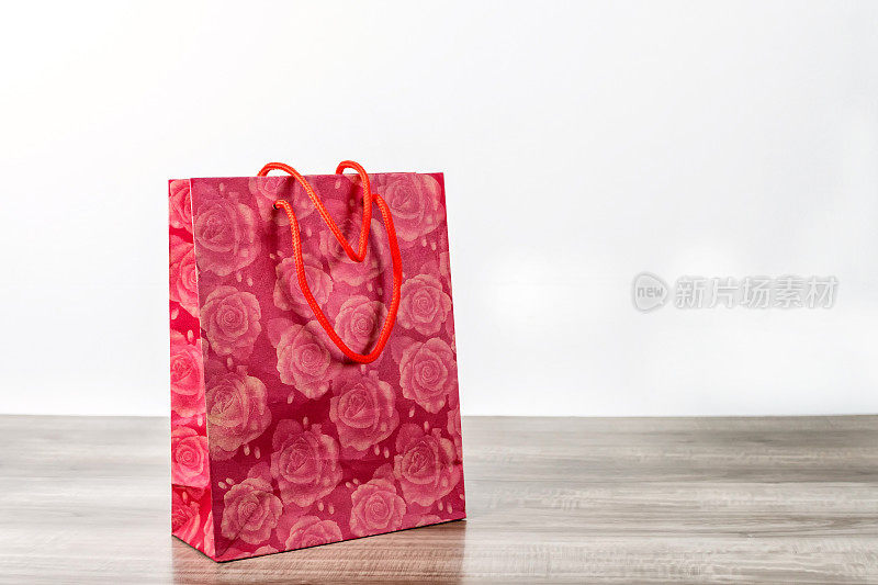 红色购物纸袋放在木桌上