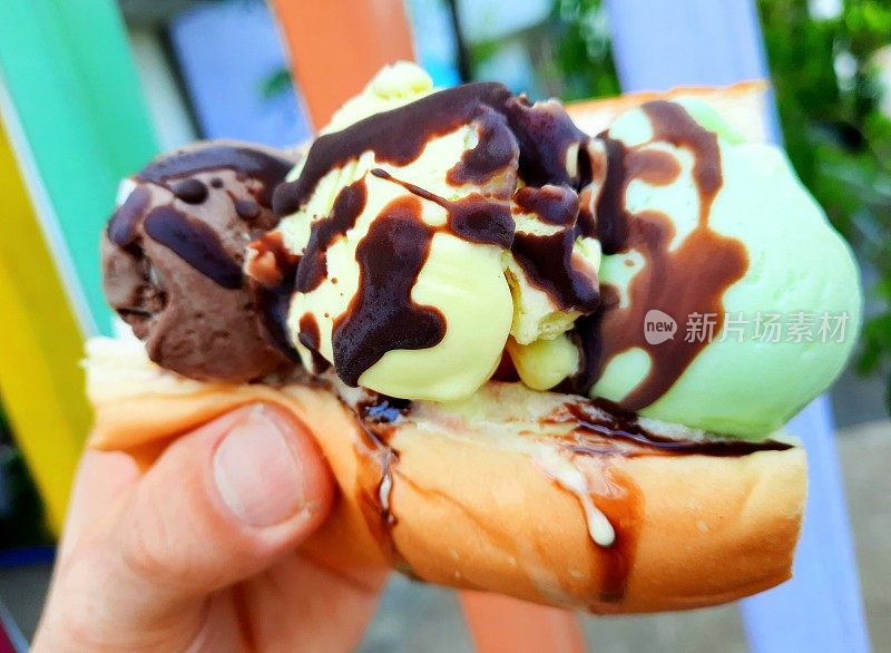 冰淇淋夹在面包、小圆面包、三明治夹在手里——曼谷街头小吃。