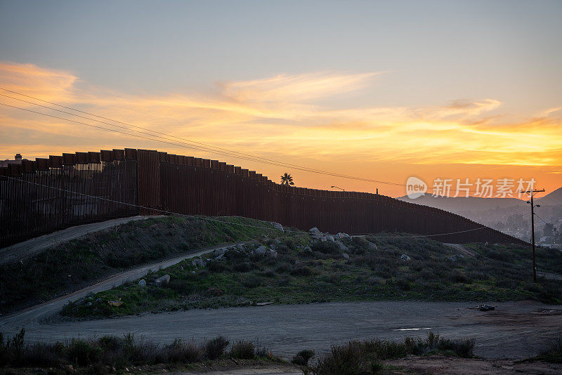 在黄昏时分，在令人惊叹的日落下，从美国俯瞰这座城市，在蒂华纳附近的加利福尼亚和墨西哥的特卡特之间的国际边界墙