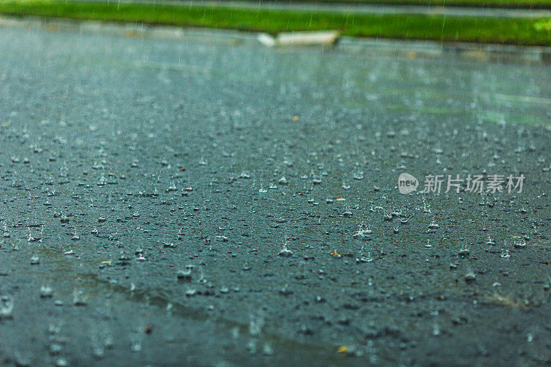 沥青路上的雨滴。天气。背景。雨