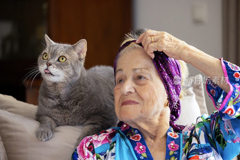 年轻漂亮的老妇人和家里的猫。