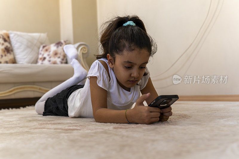 女孩在家里使用智能手机。