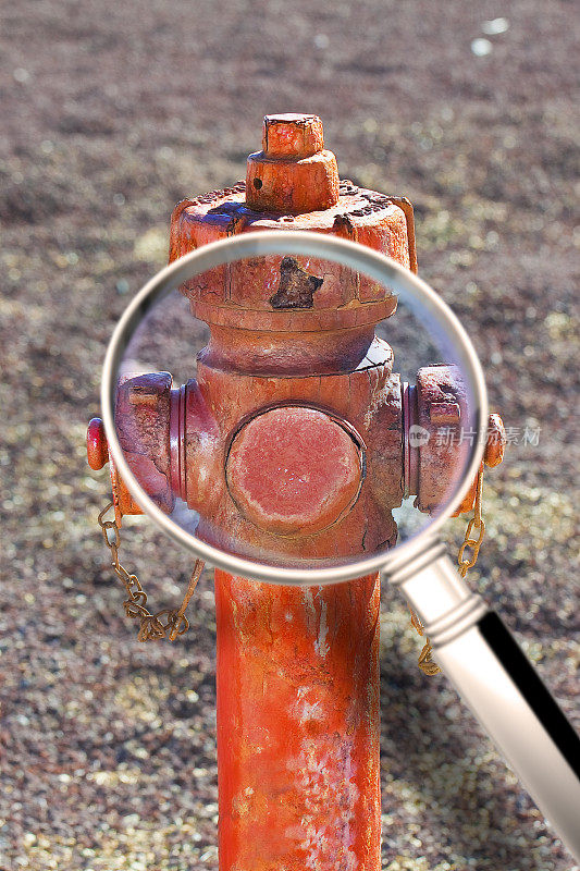旧的红色生锈的消防栓不再使用-通过放大镜看到的概念图像