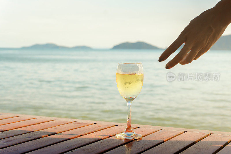 海边的木桌上放着白酒杯