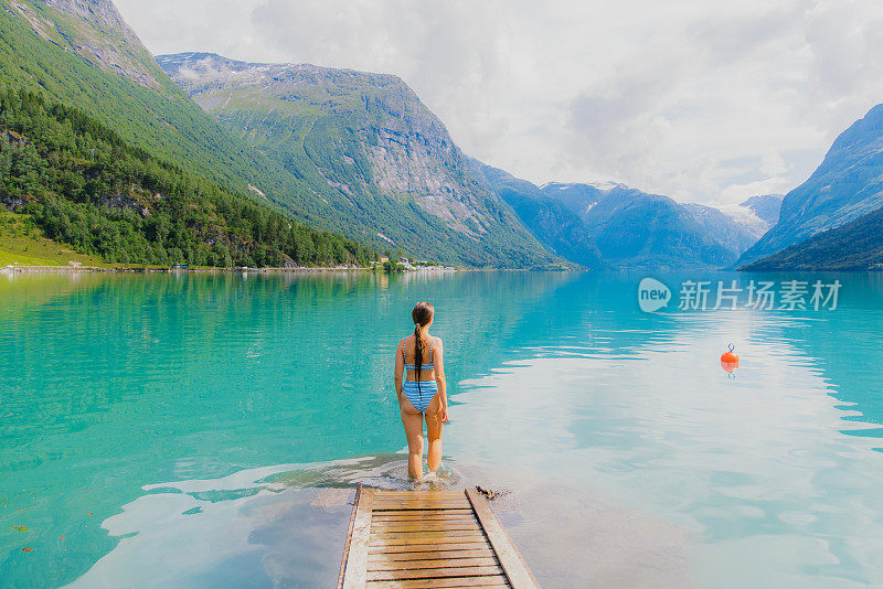 快乐的女人欣赏夏天在水晶山湖游泳