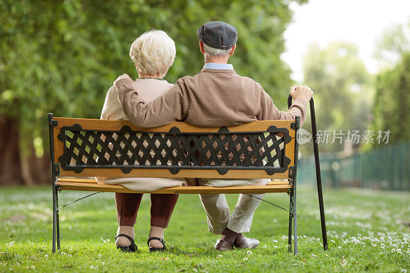 一对老年夫妇坐在公园的木凳上