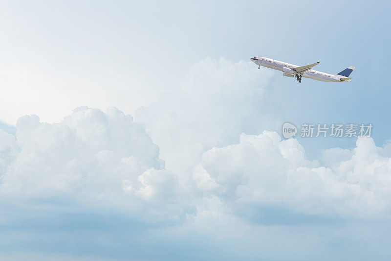 一架商业飞机飞过湛蓝的天空和白云。