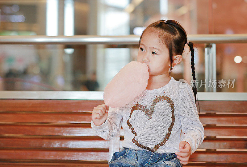 一个小女孩在吃甜而松软的糖果。