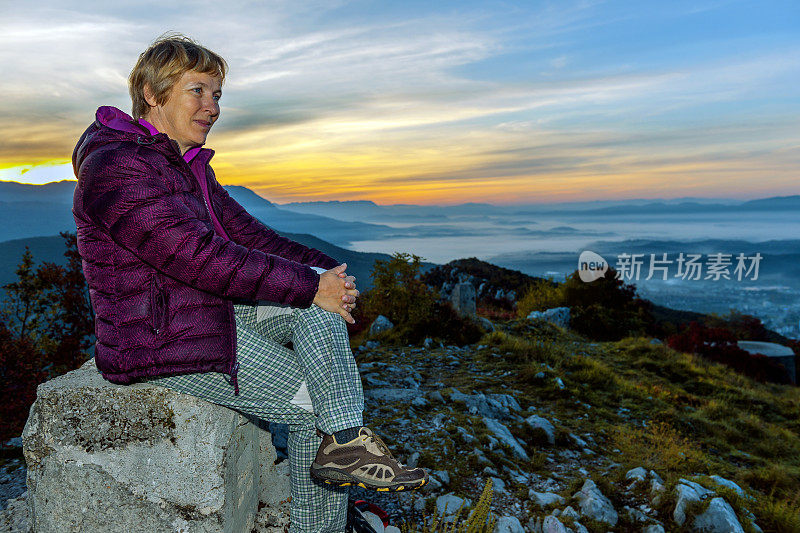 在欧洲斯洛文尼亚的朱利安阿尔卑斯，快乐的老妇人坐在山顶上