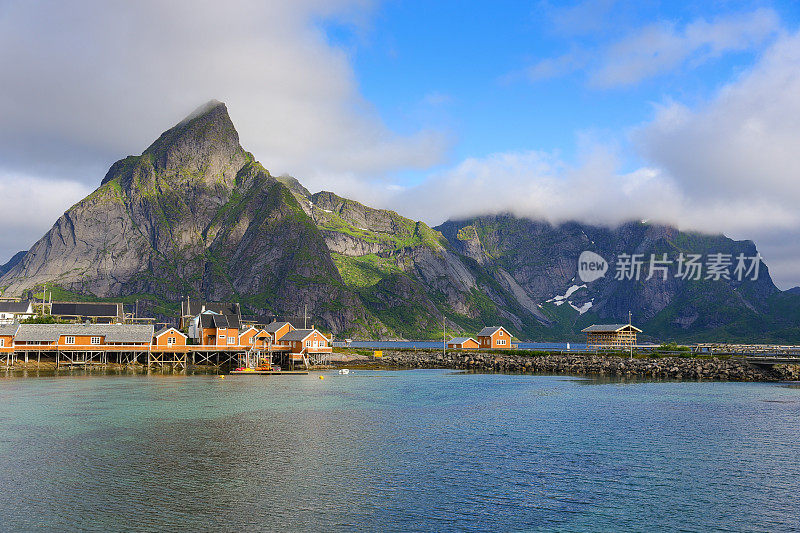 挪威的一个渔村，位于挪威罗浮敦群岛。壮观的晚霞在陡峭的山峰上移动。