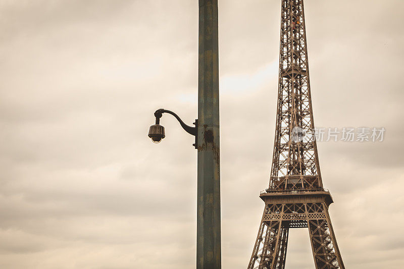 恶劣天气下埃菲尔铁塔前一根柱子上的黑色安全摄像头