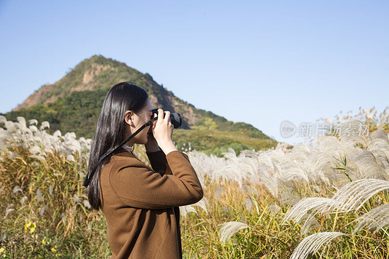 在草地上拍照的女人