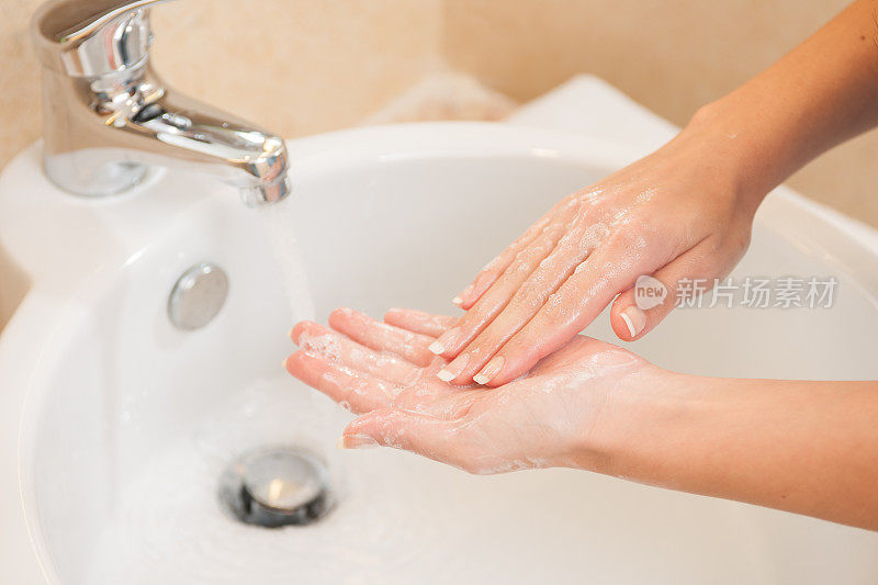 特写的女人用肥皂洗手在水槽