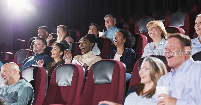 多民族观众在电影院大笑