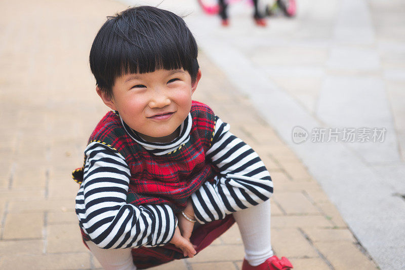 可爱的中国小女孩坐在地上